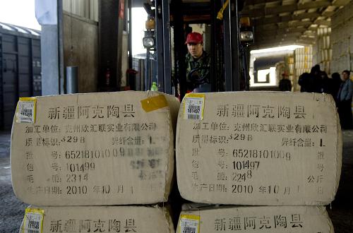 圖為棉花儲運(yùn)站的工人在轉(zhuǎn)運(yùn)棉花(11月5日攝)。進(jìn)入11月以來,新疆棉花外運(yùn)進(jìn)入高峰,鐵路部門每日計(jì)劃運(yùn)送不少于300個(gè)車皮、約1.35萬噸棉花出疆。在目前運(yùn)力緊張的情況下,鐵路部門加大向?yàn)豸斈君R鐵路局調(diào)控車輛,盡全力完成新疆棉花外運(yùn)任務(wù)。新華社記者 江文耀 攝