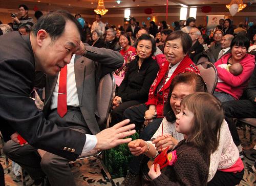 2月13日,在加拿大首都渥太華舉行的春節(jié)大廟會(huì)上,中國(guó)駐加拿大大使章均賽向小朋友們派發(fā)紅包。新華社記者張大成攝