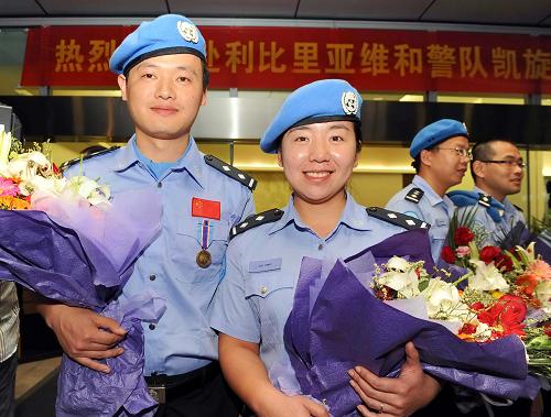 8月1日晚,從利比里亞完成任務(wù)歸國的中國維和警察劉英(前右)與趙鑫國(前左)在杭州蕭山國際機場受到熱烈歡迎。 當(dāng)日,我國第9支赴利比里亞維和警隊的18名維和警察圓滿完成任務(wù)歸國。這支維和警隊由浙江省公安機關(guān)組建,于2010年6月赴利比里亞執(zhí)行任務(wù)。 新華社發(fā)(袁云 攝)