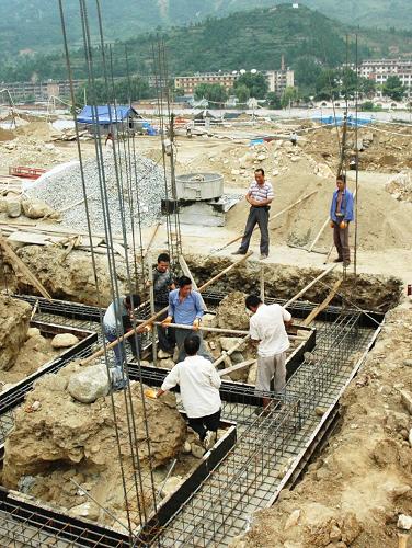 8月8日,災(zāi)后重建戶戶主在自己的新房工地上查看施工情況。新華社記者姜偉超攝