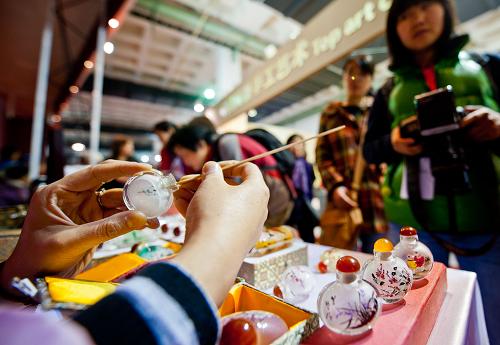 11月10日,民間工藝大師在展示老北京民間絕技內(nèi)畫鼻煙壺。新華社記者 張宇 攝