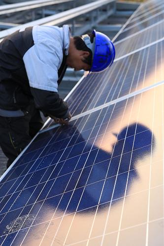 11月10日,工人在山東青島一家企業(yè)安裝太陽能電池板。新華社發(fā)(梁孝鵬 攝)