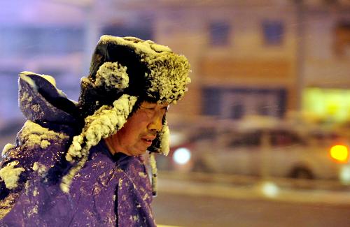 11月22日,一名沈陽市民冒雪走在路上。新華社發(fā)(張文魁 攝)