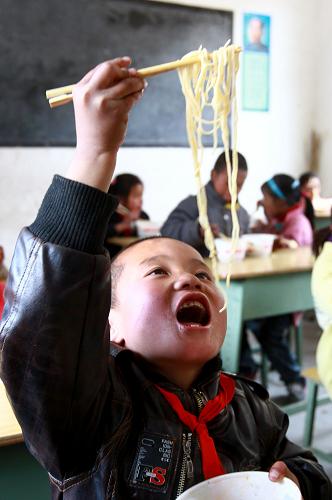 12月13日,喜德縣則約鄉(xiāng)前進(jìn)小學(xué)三年級的加巴有坡在享用“愛心午餐”。新華社記者 裴鑫 攝