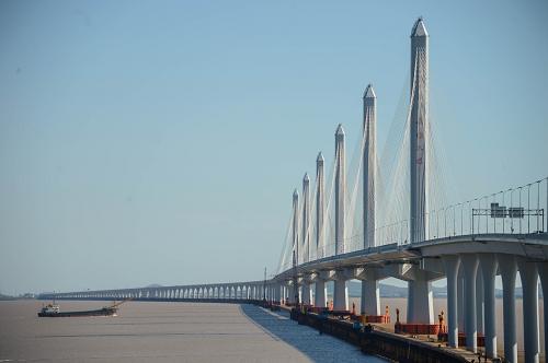 7月18日拍攝的嘉紹大橋。 當日,嘉紹跨海大橋舉行通車儀式,歷時4年多建設的嘉紹跨海大橋及南北接線工程正式建成通車,順利進入運營階段。大橋將于2013年7月19日零時零分正式對社會車輛開放,通車運行。 嘉紹跨海大橋為六塔獨柱雙幅四索面鋼箱梁斜拉橋,其中主航道橋為六塔五孔全長2680米的設計,建成以后將是目前世界上最長最寬的多塔斜拉橋,主通航孔滿足通航3000噸級集裝箱船的需要。 嘉紹跨海大橋于2008年底動工,是繼杭州灣跨海大橋之后第二座跨杭州灣大橋,總投資約139億元。其中跨越杭州灣部分長約10公里,按高速公路標準建設,設計時速為100公里。嘉紹跨海大橋建成后,浙江紹興到上海的車程將縮短近一半。 新華社記者徐昱攝