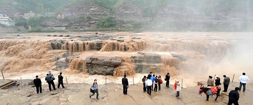 黃河壺口瀑布現(xiàn)近十年來同期最大水量 9月25日,游客在山西吉縣黃河壺口瀑布景區(qū)游覽。 當日,黃河壺口瀑布景區(qū)出現(xiàn)近十年來同期最大的一次水量,主瀑布寬度接近200米,與副瀑布連成一片,氣勢磅礴,場面十分壯觀。 受近日內(nèi)蒙古河套東部、山西中北部、陜西北部大面積地區(qū)降雨影響,位于黃河晉陜大峽谷的壺口瀑布水量大增。據(jù)吳堡水文站測量,短時最大水流量突破每秒5000立方米。 新華社發(fā)(閆銳鵬 攝)