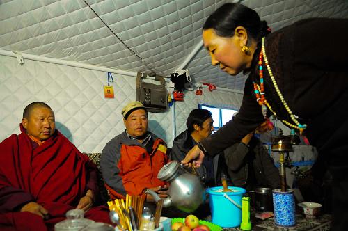 11月17日,藏族婦女永吉巴毛在暖和的屋內(nèi)為客人們倒上熱茶。 寒風(fēng)凜冽,草原漸黃。經(jīng)歷了7.1級(jí)大地震破壞的青海省玉樹藏族自治州迎來了災(zāi)后的第一個(gè)冬季。在各援建單位的努力下,目前已有部分群眾搬進(jìn)了新居中。還沒有搬進(jìn)新居的群眾領(lǐng)到了政府配發(fā)的棉帳篷。他們升起火爐,燒起牛糞,帳篷里暖意融融。 據(jù)了解,青海省民政部門自9月初開始向?yàn)?zāi)區(qū)調(diào)撥過冬棉帳篷及各類生活物資,目前相關(guān)工作已基本落實(shí)到位。截至目前,已向玉樹災(zāi)區(qū)發(fā)放20平方米過冬棉帳篷4.55萬頂;發(fā)放成品糧1.37億多噸;發(fā)放各類生活補(bǔ)助金4.45億元,資金發(fā)放工作正在進(jìn)行之中。 新華社記者 吳光于 攝