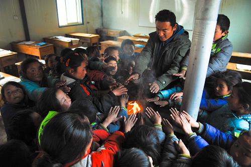 11月15日,玉樹縣下拉秀中心寄校老師扎西丹周和學(xué)生們一起圍著剛生起火的爐子烤火。 寒風(fēng)凜冽,草原漸黃。經(jīng)歷了7.1級(jí)大地震破壞的青海省玉樹藏族自治州迎來了災(zāi)后的第一個(gè)冬季。在各援建單位的努力下,目前已有部分群眾搬進(jìn)了新居中。還沒有搬進(jìn)新居的群眾領(lǐng)到了政府配發(fā)的棉帳篷。他們升起火爐,燒起牛糞,帳篷里暖意融融。 據(jù)了解,青海省民政部門自9月初開始向?yàn)?zāi)區(qū)調(diào)撥過冬棉帳篷及各類生活物資,目前相關(guān)工作已基本落實(shí)到位。截至目前,已向玉樹災(zāi)區(qū)發(fā)放20平方米過冬棉帳篷4.55萬頂;發(fā)放成品糧1.37億多噸;發(fā)放各類生活補(bǔ)助金4.45億元,資金發(fā)放工作正在進(jìn)行之中。 新華社記者 吳光于 攝