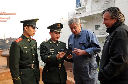 這是曹妃甸邊防檢查站民警在25萬噸礦石碼頭檢查一上岸外國船員的證件(2010年12月29日攝)。 2010年12月31日,記者從曹妃甸邊防檢查站獲悉,曹妃甸口岸通航5年來,接待入出境船舶3520艘次,以平均每年113.5%的速度遞增。據(jù)曹妃甸統(tǒng)計部門的數(shù)據(jù)顯示,該口岸貨物吞吐量5年來累計達到26673.1萬噸,以平均每年87.5%的速度遞增。業(yè)務范圍也由2005年開港時,單一的礦石業(yè)務發(fā)展到現(xiàn)在的集礦石、煤炭、原油、集裝箱、鋼鐵等物資進出口的綜合性口岸。 新華社記者 楊世堯 攝