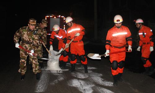1月12日凌晨,負責護送的消防官兵在車隊通過前向路面拋灑鹽巴化解凝冰。 連日來,受雪凝天氣影響,貴州省畢節(jié)地區(qū)金沙縣交通運輸中斷,燃油供應(yīng)嚴重告急,而長時間的雪凝天氣導致貴陽到金沙公路路面凝凍狀況嚴重,送油車隊的行程艱難而緩慢。1月11日晚,金沙消防大隊派出一輛指揮車、兩輛水罐消防車和10名消防官兵參加護送燃油任務(wù)。1月12日凌晨5時許,經(jīng)過6個小時的路程,消防官兵將12輛油罐車滿載的近200噸油料成功運送到金沙縣城。 新華社發(fā)(譚永紅 攝)