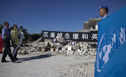1月12日,在海地首都太子港,中國赴海地維和警察防暴隊(duì)隊(duì)員們在聯(lián)合國駐海地穩(wěn)定特派團(tuán)(聯(lián)海團(tuán))總部舊址廢墟前舉行儀式,悼念在去年地震中遇難的戰(zhàn)友。2010年1月12日,海地發(fā)生里氏7.3級強(qiáng)烈地震,8位中國維和警察在地震中不幸遇難。 新華社發(fā)