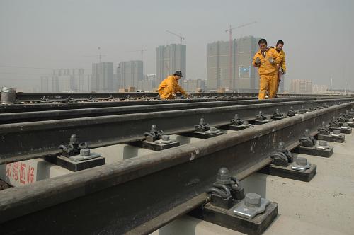 1月23日,施工人員在鄭州新東站建設工地鋪設軌道。 目前,高速鐵路客運專線鄭州新東站工程已開始鋪設道軌,主樓建設工程也初具雛形。據(jù)介紹,鄭州新東站是國家鐵路網(wǎng)中的重要樞紐,位于新建京廣客運專線和徐蘭(徐州-蘭州)客運專線十字交會處。鄭州新東站總建筑面積39.2萬平方米,共設正線、到發(fā)線32條,站臺30座,項目投資75億元,總工期30個月。 新華社發(fā)(楊正華 攝)