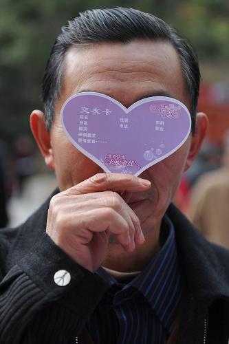 2月14日,一位市民用相親“交友卡”遮擋自己。 當日是西方的情人節(jié),貴陽市黔靈山公園內(nèi)舉行“情緣時分·迎春相親大會”,吸引眾多市民參與。 新華社記者 歐東衢攝