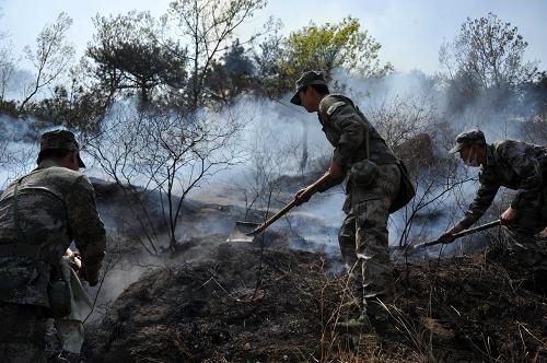 4月20日,在泰山余脈山火現(xiàn)場(chǎng),解放軍官兵在撲滅山火。 受夜間大風(fēng)天氣影響,已經(jīng)撲滅的泰山余脈山火當(dāng)日再現(xiàn)多處明火,目前已經(jīng)有5000多名軍民聯(lián)合救火力量上山撲救,同時(shí)兩架直升機(jī)也在協(xié)助滅火。 新華社記者 徐速繪 攝