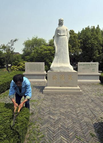 5月18日,一名工作人員在江蘇江陰市徐霞客塑像前修剪綠色植物。 5月19日是首個(gè)“中國旅游日”,這一天也是明朝大旅行家徐霞客著名的《徐霞客游記》開篇之日。在首個(gè)“中國旅游日”之際,記者來到江蘇江陰,探訪徐霞客故居。 新華社發(fā)(潘正光 攝)
