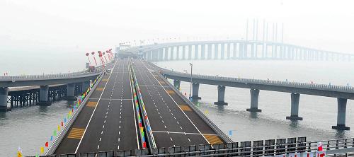 6月30日,通車儀式前拍攝的青島膠州灣大橋紅島互通立交。 當(dāng)日,青島膠州灣大橋正式通車,這是我國北方冰凍海域首座特大型橋梁集群工程,是國道主干線青島至蘭州高速公路的起點(diǎn)段,大橋全長36.48公里,是目前世界上已建成的最長的跨海大橋。大橋起于青島市東部高科園,跨越膠州灣,在黃島側(cè)與已建成的濟(jì)青南線順接,使青島、黃島和紅島實(shí)現(xiàn)“品”字形連接。大橋?yàn)殡p向六車道高速公路兼城市快速路八車道,設(shè)計(jì)行車速度80公里每小時(shí),橋梁寬度35米,設(shè)計(jì)基準(zhǔn)期100年。 新華社記者 李紫恒 攝