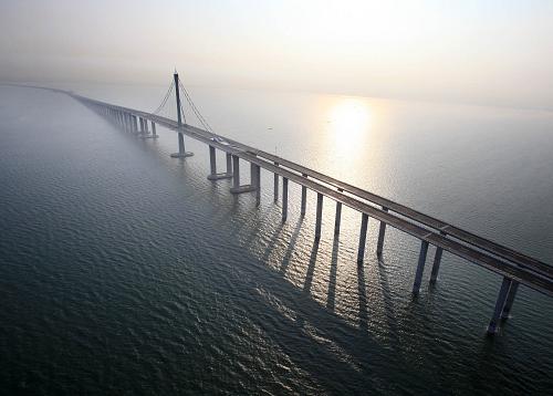 青島膠州灣大橋大沽河航道橋鳥瞰(6月29日攝)。 6月30日,青島膠州灣大橋正式通車,這是我國北方冰凍海域首座特大型橋梁集群工程,是國道主干線青島至蘭州高速公路的起點(diǎn)段,大橋全長36.48公里,是目前世界上已建成的最長的跨海大橋。大橋起于青島市東部高科園,跨越膠州灣,在黃島側(cè)與已建成的濟(jì)青南線順接,使青島、黃島和紅島實(shí)現(xiàn)“品”字形連接。大橋?yàn)殡p向六車道高速公路兼城市快速路八車道,設(shè)計(jì)行車速度80公里每小時(shí),橋梁寬度35米,設(shè)計(jì)基準(zhǔn)期100年。 新華社發(fā)