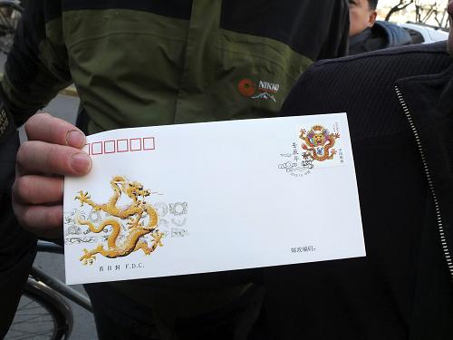 《壬辰年》“龍”郵票發(fā)行受歡迎 1月5日,在北京市南區(qū)郵票公司旁,一名《壬辰年》生肖“龍”郵票購買者展示剛剛買到的郵品。 當日,《壬辰年》郵票開始發(fā)行。這張《壬辰年》生肖“龍”郵票,在設計上基本參考了明清蟠龍的造型,是第三輪生肖“龍”郵票。 新華社發(fā)(孫瑞博攝)