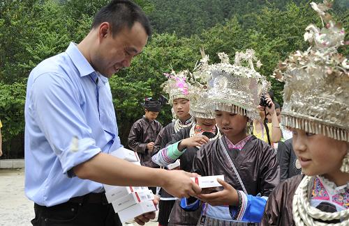 5月29日,來自北京的志愿者為六甲小學(xué)的侗族兒童發(fā)放存有童話故事的MP3播放器。 當(dāng)日,“上學(xué)路上”關(guān)注留守兒童公益行動在貴州省黎平縣龍額鎮(zhèn)六甲小學(xué)啟動,志愿者們?yōu)榇笊缴钐幍牧羰貎和蛠?00多臺存有經(jīng)典童話故事音頻的MP3播放器,40多位社會各界精英為兒童們誦讀并錄制了經(jīng)典童話故事。 新華社記者 李欣 攝