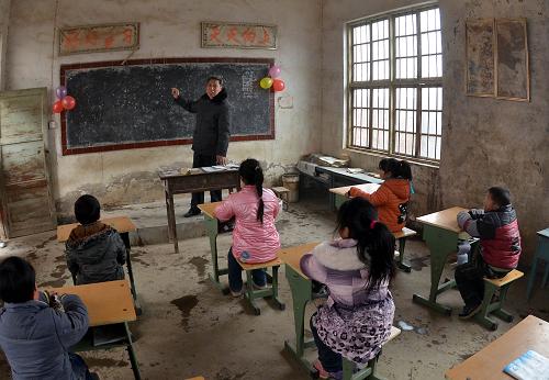 在河南省洛陽(yáng)市伊濱區(qū)封溝村小學(xué),即將退休的教師張其昌在為學(xué)生上最后一堂語(yǔ)文課(2012年2月26日攝)。 為進(jìn)一步改善農(nóng)村中小學(xué)辦學(xué)條件,從2013年起,河南省提高了農(nóng)村校舍維修補(bǔ)助標(biāo)準(zhǔn),由每平方米400元增至600元。保障范圍也由原來(lái)的日常維修改造,擴(kuò)展為維修改造和抗震加固。按河南省教育廳的文件要求,專(zhuān)項(xiàng)資金主要用于農(nóng)村義務(wù)教育階段公辦中小學(xué)的教學(xué)及教學(xué)輔助用房、行政辦公用房、學(xué)生生活服務(wù)用房等校舍的維修改造。項(xiàng)目的規(guī)劃既要達(dá)到當(dāng)?shù)刂攸c(diǎn)設(shè)防類(lèi)抗震設(shè)防標(biāo)準(zhǔn),還要做到不搞超標(biāo),避免資金浪費(fèi)。 新華社記者 王頌 攝