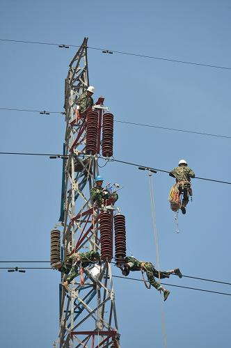 7月22日,國(guó)家電網(wǎng)河北秦皇島供電公司的電力工人在更換懸掛絕緣子。 近日,秦皇島供電公司對(duì)跨越鐵路京哈線(北京-哈爾濱)、大秦線(大同-秦皇島)的110千伏李(李莊)鐵(鐵莊)線進(jìn)行電力線路改造施工。據(jù)了解,該段改造線路采取了由鐵塔單懸垂絕緣子串改為雙懸垂絕緣子串的技術(shù)措施,僅用時(shí)1小時(shí)40分鐘,就完成了560米架空導(dǎo)線的更換工作,為鐵路大動(dòng)脈安全行車提供了保障。 新華社發(fā)(王勝利 攝)