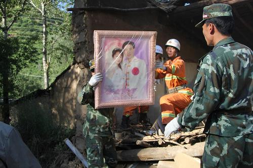7月22日,在甘肅岷縣梅川鎮(zhèn)永光村,救援官兵將一對夫妻的結(jié)婚照從廢墟中搬了出來。 據(jù)甘肅省抗震救災(zāi)指揮部統(tǒng)計,截至22日晚,甘肅省定西市岷縣漳縣交界地震災(zāi)害共造成定西、隴南、天水、白銀、臨夏、甘南6個市州的22個縣區(qū)、204個鄉(xiāng)鎮(zhèn)、12.3萬人受災(zāi);因災(zāi)死亡89人,失蹤5人,受傷800多人;緊急轉(zhuǎn)移安置3.16萬人。 新華社發(fā)(趙志剛 攝)