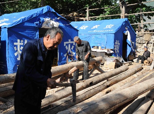 自力更生 重建家園 7月2日,舟曲縣咀上村村民對從廢墟中挖出的建筑材料進行加工,用來搭建新房。甘肅省甘南藏族自治州舟曲縣咀上村共有120戶村民,在汶川大地震中有95戶受災(zāi),32戶房屋倒塌。在重建家園過程中,當(dāng)?shù)厥転?zāi)村民不等不靠,自己動手搭建住房。 新華社記者 陳樹根 攝