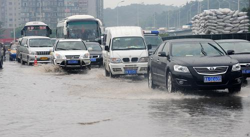 6月19日,暴雨襲擊造成長(zhǎng)沙城區(qū)低洼路段出現(xiàn)積水,車(chē)行緩慢。新華社記者龍弘濤攝