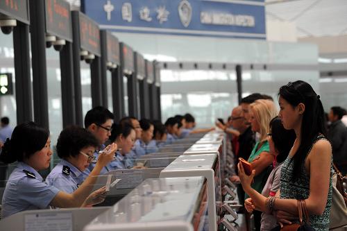 6月30日,北京邊檢民警在首都國際機(jī)場為入境旅客辦理手續(xù)。自7月1日起,《中華人民共和國出境入境管理法》開始實(shí)施?!吨腥A人民共和國外國人入境出境管理法》和《中華人民共和國公民出境入境管理法》同時廢止。新華社記者 唐召明 攝