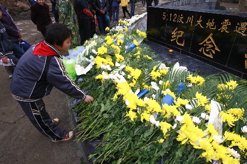 11月12日,一名學(xué)生在青川東河口地震遺址公園向遇難者獻(xiàn)花。