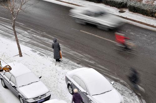 2月10日,一位市民站在雪中等車。當(dāng)日,天津迎來兔年首場大范圍降雪,氣溫明顯降低。新華社記者 岳月偉 攝