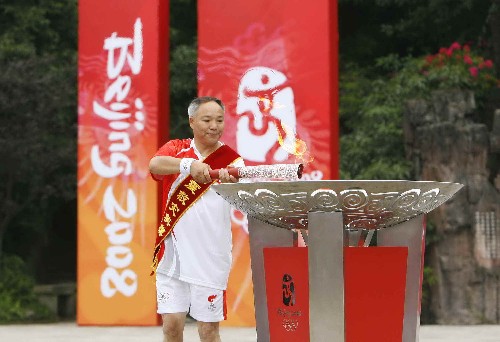 8月4日,最后一棒火炬手抗震救災(zāi)英模代表、汶川縣映秀小學(xué)教師譚國強(qiáng)點燃圣火盆。當(dāng)日,北京奧運(yùn)圣火在四川省樂山市傳遞。 新華社記者 魯金博 攝