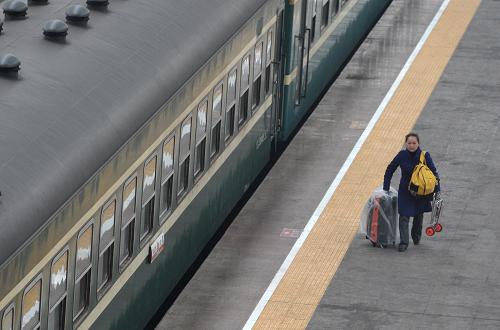 2月27日,一位剛在合肥站下車的旅客準備出站。 當日,為期40天的春運進入最后一天,據(jù)鐵道部的統(tǒng)計,2011年春運鐵路運送旅客超過2.1億人,比2010年多發(fā)送1000萬人,日均運送旅客能力達620萬人,能力增長幅度為歷史最大,鐵路春運秩序正常。另外,公路、民航運送旅客同比均有增長。 新華社記者 郭晨 攝