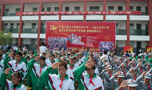 8月26日,在銀川市永寧耿飚紅軍小學(xué),同學(xué)們在授旗授牌儀式上向國旗敬禮。當(dāng)日,全國紅軍小學(xué)建設(shè)工程理事會在銀川市永寧縣舉行“永寧耿飚紅軍小學(xué)”、“六盤山紅軍小學(xué)”、“鹽池毛澤民紅軍小學(xué)”等三所紅軍小學(xué)的授旗授牌儀式。在儀式上,全國紅軍小學(xué)建設(shè)工程理事會、紅軍后代以及愛心企業(yè)向三所紅軍小學(xué)共捐贈六十萬元,并向每所學(xué)校捐贈電教設(shè)備、圖書和校服等。據(jù)了解,這是寧夏回族自治區(qū)首次建設(shè)紅軍小學(xué)。新華社記者李琰攝