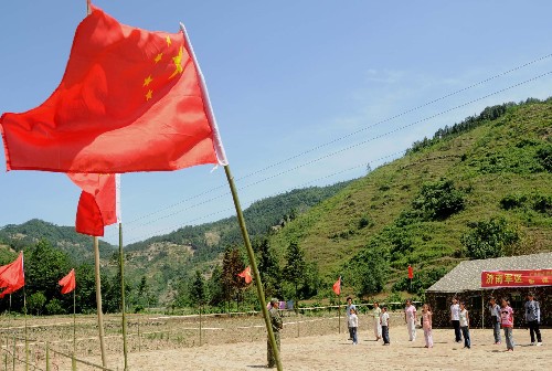 在四川青川縣板橋鄉(xiāng),救災(zāi)部隊幫助鄉(xiāng)里搭建了帳篷學(xué)校,學(xué)校周圍插滿了五星紅旗(6月2日攝)。 青川是大地震中受災(zāi)最嚴(yán)重的地區(qū)之一。地震發(fā)生后,青川縣專門購置了7500多面國旗,下發(fā)到每個安置點和每家每戶。到處飄揚的五星紅旗極大鼓舞了人們抗震救災(zāi)的士氣。 新華社記者 楊金志 攝