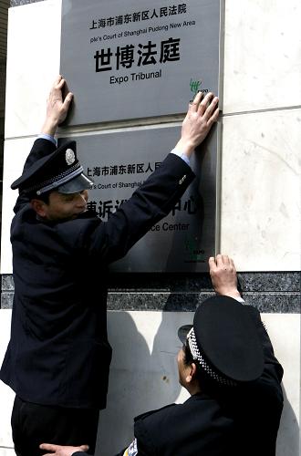 3月25日,法院工作人員正在懸掛“世博法庭”的牌子。新華社記者 陳飛 攝