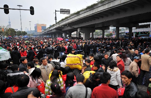 1月27日,廣州火車站廣場(chǎng)邊的道路成為臨時(shí)候車場(chǎng),眾多進(jìn)不了候車室的旅客在這里候車。受惡劣天氣影響,廣州火車站大多數(shù)旅客列車晚點(diǎn)、停運(yùn),截至記者發(fā)稿時(shí),廣州火車站滯留旅客超過17萬(wàn)。 新華社記者 陳學(xué)思 攝