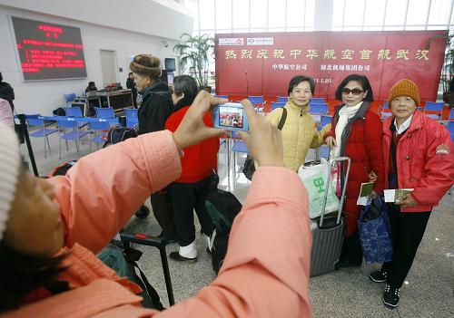 1月26日,乘坐臺灣中華航空武漢——臺北首航班機的幾名臺灣旅客在武漢天河機場合影。新華社 發(fā)