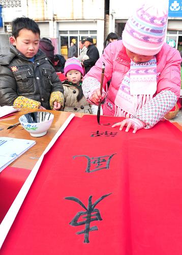 1月26日,巢湖市居巢區(qū)少兒書(shū)法愛(ài)好者在夏閣鎮(zhèn)街頭義務(wù)為群眾寫(xiě)春聯(lián)。當(dāng)日,安徽省巢湖市15名少兒書(shū)法愛(ài)好者來(lái)到居巢區(qū)夏閣鎮(zhèn)義務(wù)為群眾寫(xiě)春聯(lián),送上新春祝福。新華社發(fā)(何希斌 攝)