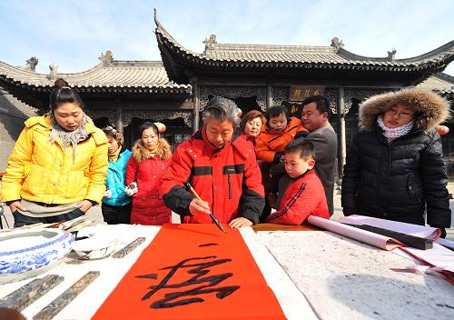 1月26日,山東棗莊市書(shū)法愛(ài)好者走進(jìn)臺(tái)兒莊古城,為人們免費(fèi)寫(xiě)春聯(lián)、送“福”字,喜迎新春。新華社發(fā)(高啟民 攝)