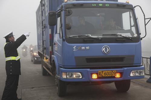 2月1日,一名交警在大霧籠罩的省道106線四川眉山段指揮車(chē)輛通行。新華社發(fā)(姚永亮 攝)