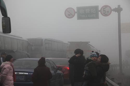 2月1日上午,車(chē)輛和行人在大霧籠罩的成樂(lè)高速公路眉山收費(fèi)站入口處排隊(duì)等候放行。新華社發(fā)(姚永亮 攝)