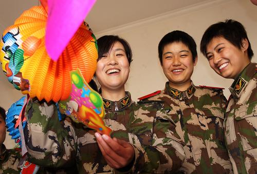 2月15日,河北邊防總隊(duì)新訓(xùn)團(tuán)女干部李秀玉(左)和新兵一起猜燈謎。新華社記者 楊世堯 攝