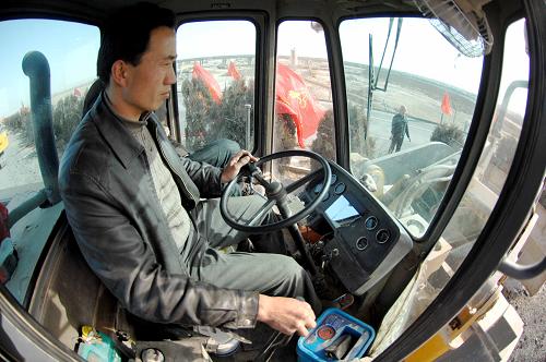 2月16日,一名工人正在國道211線A8合同段的建設工地上駕駛挖掘機。新華社記者 彭昭之 攝