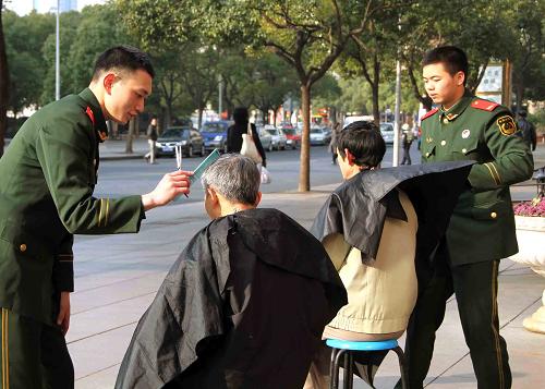3月5日,武警戰(zhàn)士在為市民義務(wù)理發(fā)。當(dāng)日,武警上??傟?duì)一支隊(duì)官兵和地方青年志愿者一起來到上海市南京路,開展“學(xué)雷鋒、展風(fēng)采”志愿服務(wù)活動(dòng),為市民義診、理發(fā)。據(jù)悉,官兵們每月20日都會(huì)在上海市人民廣場(chǎng)區(qū)域開展義務(wù)理發(fā)、健康檢查、手機(jī)維修等便民利民服務(wù),受到周邊市民的贊揚(yáng)。新華社記者 陳飛 攝