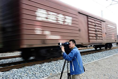 6月29日,一名記者在拍攝行駛的電氣化列車。當日,全長834公里的青藏鐵路西寧至格爾木段電氣化正式開通。據(jù)介紹,青藏鐵路西寧至格爾木段電氣化于2008年5月6日開工建設,總投資13.15億元。全線變電所無人值守,統(tǒng)一由青藏鐵路公司供電調(diào)度室利用遠動系統(tǒng)和視頻安全監(jiān)控系統(tǒng)進行管理。工程采用了國產(chǎn)核心技術(shù),設計時速為160公里。開通運營后,將大大縮短此區(qū)間的行車時間。新華社記者 張宏祥 攝