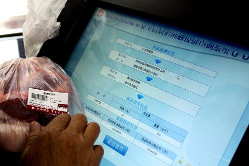 9月20日,一名顧客使用肉品質(zhì)量安全信息追溯查詢機(jī)查詢所購(gòu)豬肉的相關(guān)信息。新華社發(fā)(孫樹寶 攝)