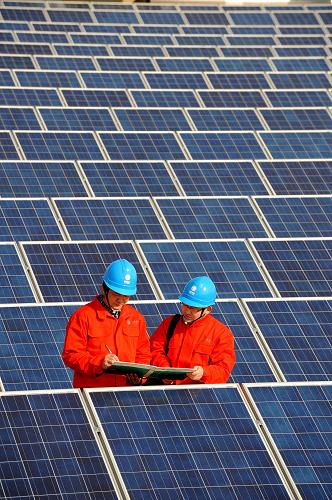 2月7日,長興縣供電局工作人員在一家企業(yè)屋頂檢查、調(diào)試光伏發(fā)電裝置,該企業(yè)屋頂剛剛安裝了5000多平方米的太陽能板,設(shè)計(jì)功率為400千瓦,正進(jìn)入調(diào)試階段。今年浙江省長興縣計(jì)劃在近20家企業(yè)的廠房屋頂上建設(shè)總面積近30萬平方米的光伏發(fā)電裝置,總共二期光伏電站總裝機(jī)容量為20兆瓦,預(yù)計(jì)2012年底前完成;建成后每年可節(jié)約1萬多噸標(biāo)準(zhǔn)煤,減少二氧化碳排放2萬多噸。利用企業(yè)屋頂閑置面積建設(shè)的“無煙發(fā)電廠”將對當(dāng)?shù)仄髽I(yè)用電和環(huán)境保護(hù)起到積極的促進(jìn)作用。新華社記者 徐昱 攝