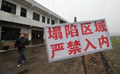 益陽市岳家橋鎮(zhèn)民房塌陷處設(shè)置的警示標識(2月26日攝)。從2012年元月至2月24日,位于洞庭湖區(qū)的湖南省益陽市岳家橋鎮(zhèn)岳家橋、黃板橋等村發(fā)生大面積的巖溶塌陷地質(zhì)災(zāi)害,上千當?shù)卮迕竦纳a(chǎn)生活受到影響。記者從益陽市國土資源局了解到,目前整個岳家橋鎮(zhèn)共出現(xiàn)塌陷693處,其中農(nóng)田塌陷537處,河溪塌陷150處,水庫內(nèi)塌陷6處。全鎮(zhèn)因地面巖溶塌陷引起房屋開裂的有167戶,其中房屋受損特別嚴重的有34戶,受災(zāi)人口達1200多人;破壞河溪攔壩5座,水庫2座,影響農(nóng)田灌溉1萬多畝,致使泉交河支流河水斷流,沿河兩岸部分群眾生產(chǎn)生活陷入困境。新華社記者 龍弘濤 攝