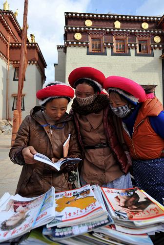 3月14日,云南香格里拉縣噶丹松贊林寺附近村莊的一些藏族姑娘在翻看圖書。這些圖書是當(dāng)?shù)匾恍┎块T免費(fèi)送給寺院里的僧人和周邊群眾的。新華社記者 藺以光 攝